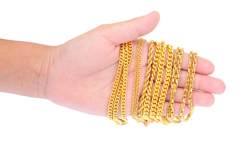 hand holding gold jewelry pimbex